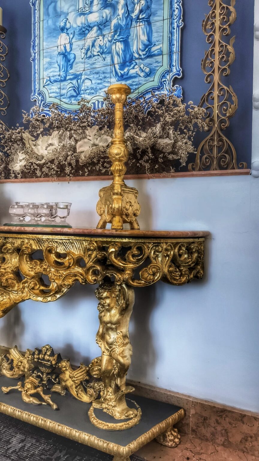 Interior view of a restored Alentejo chapel with blue-and-white azulejos and gilded baroque furnishings.